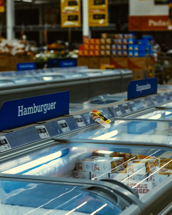 Frozen-food aisle in a supermarket with glass-door display cases and LED lighting running on R407F refrigeration