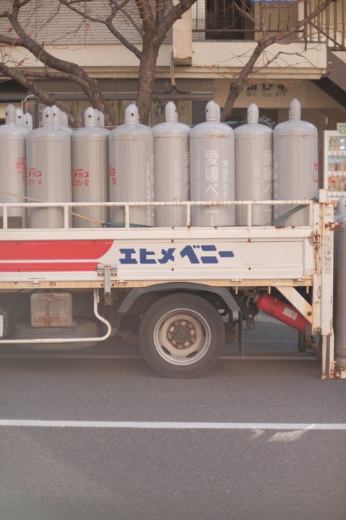 Delivery truck loaded with pressurised gas cylinders, illustrating how refrigerant gas is transported as dangerous goods